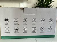 Box side showing camera features icons: HD image, wireless networking, true wireless, PIR detection, two way audio, waterproof and dustproof, activity zone, infrared night vision, battery powered, phone monitoring, AI recognition, cloud storage