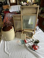 Overall lot laid out on white sheet including Medalta jug, Spong meat mincer with box and paperwork, and two vintage washboards.