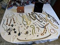 Top view of all costume jewelry pieces spread on a surface showing the various necklaces, bracelets, rings and other jewelry items.