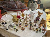 Wide view of the entire collection including various stuffed animals and character figurines arranged on a white cloth.