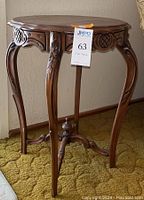Front angled view of antique wooden side table showing carved legs and structural detail