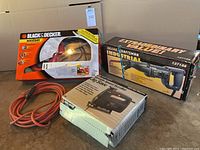 Lot photo showing boxed Black & Decker 2-in-1 Convertible Handsaw and Jigsaw SC500, boxed Sears Craftsman Reciprocating Saw 927188, boxed Black & Decker Jig Saw 7588, and orange extension cord coiled beside them.