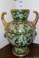 Front view of green hand-painted urn with floral and pheasant design, two gold-tone handles, and gold accents