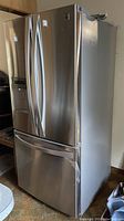Full view of stainless steel refrigerator with French doors and bottom freezer.