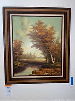 Full view of framed landscape oil painting by Harluck featuring trees and water.