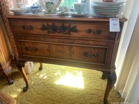 Front view of small solid wood antique credenza showcasing its general shape, size and surface.
