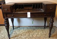 Full front view of the vintage desk showing spindle legs, two side drawers open, and central cubby compartment.