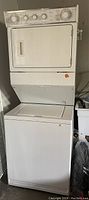 Full view of the white Whirlpool stacking washer dryer combo unit with visible control panel and washer lid closed.