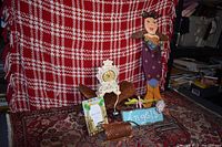 Wide view of various miscellaneous household items including fairy figurine, decorative clock, framed piece, copper grater, and other small objects