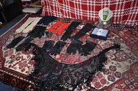 Full view of gloves and lace shawls laid out on patterned rug