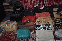 Full view of 14 handbags showing variety of colors and designs including woven, quilted, floral, and bamboo handles.