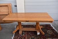Photo of solid red oak desk with flat top, sturdy double pedestals and horizontal stretcher base, placed on patterned rug in front of a metal roller door.
