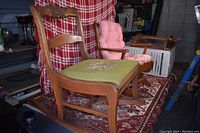 Photo showing the wooden chair with carved floral design on backrest and green needlepoint seat embroidered with roses.