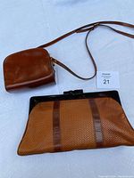 Photo of two brown vintage Italian purses, one crossbody and one clutch, displayed on light surface