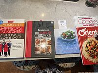 Top view of all five cookbooks laid out on a table showing full covers and titles.