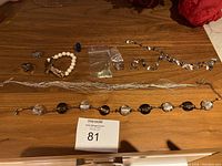 Full lot overview showing all jewelry items laid out on wooden surface