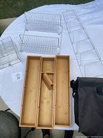 Overview of all items: metal wall shelves, bamboo organizer, lucite organizer, car organizer, displayed on white cloth.