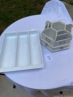 Top view of plastic utensil drawer divider and spinning desk organizer on a white cloth surface outdoors