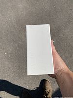 Photo of a sealed package box with white porcelain tiles inside.