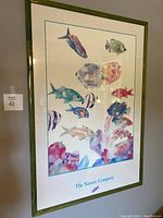 Framed fish print with colorful watercolor fish and green stained wood frame, showing aquatic theme and size.