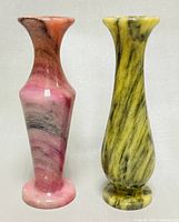 Front view of two small natural stone vases, showing their colors and shape