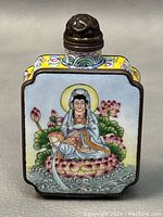 Front view of snuff bottle illustrates hand-painted figure seated on lotus flower in water with surrounding lotus leaves.