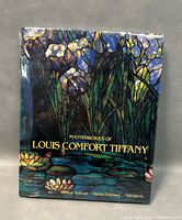 Front view of the book showing colorful stained glass floral cover artwork with title.