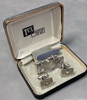 Full set displayed in original TUX branded lined box showing cufflinks and tie bar.