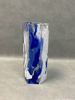 Front and angled view of a clear glass vase with thick walls and embedded cobalt blue and white swirls, hand-blown glass texture visible.