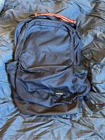 Front view of black Adidas backpack showing zippered compartments and Adidas logo on front pocket.