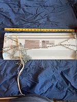 Back view of the light fixture showing the label with electrical information and certifications, hanging chains, and power cord.