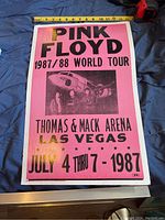 Front view of Pink Floyd poster on blue surface with measuring tape showing width around 20 inches.
