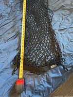 Cargo net laid out flat with measuring tape showing length approximately 30 inches