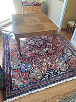 Wooden table positioned on rug showing full layout and scale