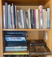 Full bookshelf showing a variety of hardcover and softcover books with focus on Canada and yacht design.