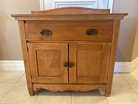 Front view of wooden Shaker style sideboard cabinet showing drawer and doors with hardware.