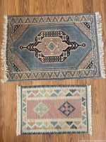 Overview photo of both floor mats on wooden floor, showing size difference and pattern details.