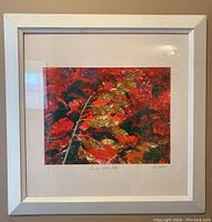 Framed print showing colorful leaves with red and gold tones, signed and numbered 1/1, titled "Loving Wild Oats".
