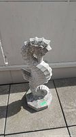 Front view of concrete seahorse statue showing detailed geometric seahorse shape and octagonal base.
