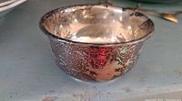 Side view of the Birks sterling silver bowl showing dents and tarnishing on the surface.