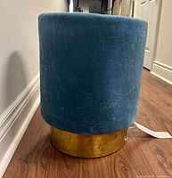 Side view of the teal crushed velvet stool showing the gold leaf base and cylindrical shape.