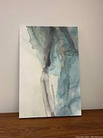 Front view of giclée abstract artwork showing fluid, organic watercolor-like forms with teal, blue, gray and beige shades on canvas with white edges.