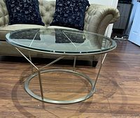 Side view showing round glass top and brushed silver metal frame with circular base and Y-shaped supports