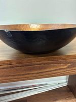 Side view of large bowl showing black exterior and hammered texture