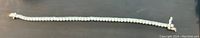 Full length view of the tennis bracelet showing the continuous row of cubic zirconia stones and clasp