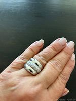 Three Tocara silver rings stacked and worn on a finger, showing size and how they look combined.