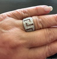 Ring worn on finger showing front Greek key cubic zirconia pattern