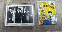 Photo showing a colored Three Stooges card packaging and black-and-white trading card #60 featuring a scene with the Stooges and women.