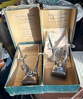 Photo showing two Brown & Sharpe vintage manual hair clippers in their original boxes with instruction booklet and other literature.
