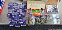 Overview of the lot including unopened 1991 Pro Set Series II packs, 1990 Topps football card box and loose cards, and other loose card stacks.